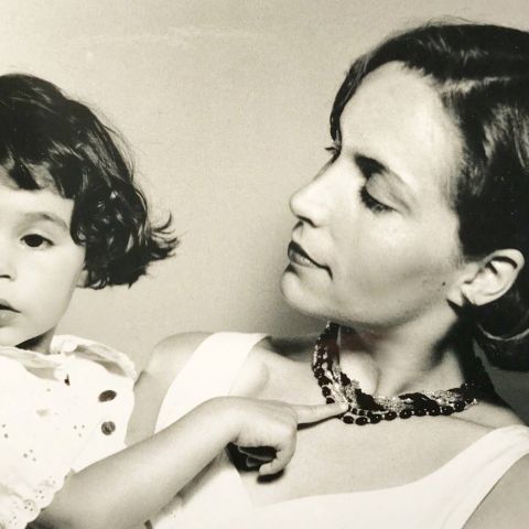 Ein Schwarz-weiß-bild von einer Frau, die ihre kleine Tochter hochhält und diese anschaut