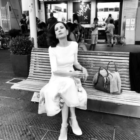 Ein Schwarz-Weiß-Bild von einer Frau in einem weißen Kleid auf einer Bank