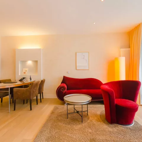 Geräumiges Wohnzimmer in einer Suite mit einem roten Sofa