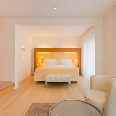 Blick auf ein großes Doppelbett in einer hellen Suite 