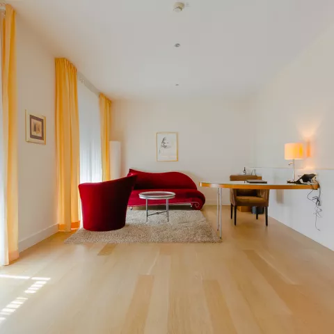 Fernfoto des roten Sofas und Sessels in der Superior-Suite zur Straßenseite