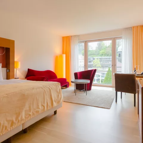 Großes Doppelbett in einem geräumigen Schlafzimmer mit Fenster