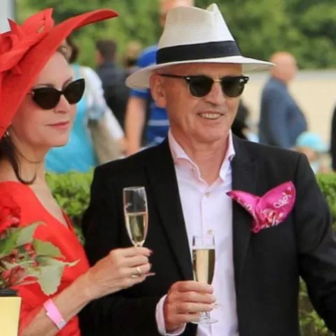 Ein Mann und eine Frau in eleganter Kleidung mit einem Sektglas in der Hand