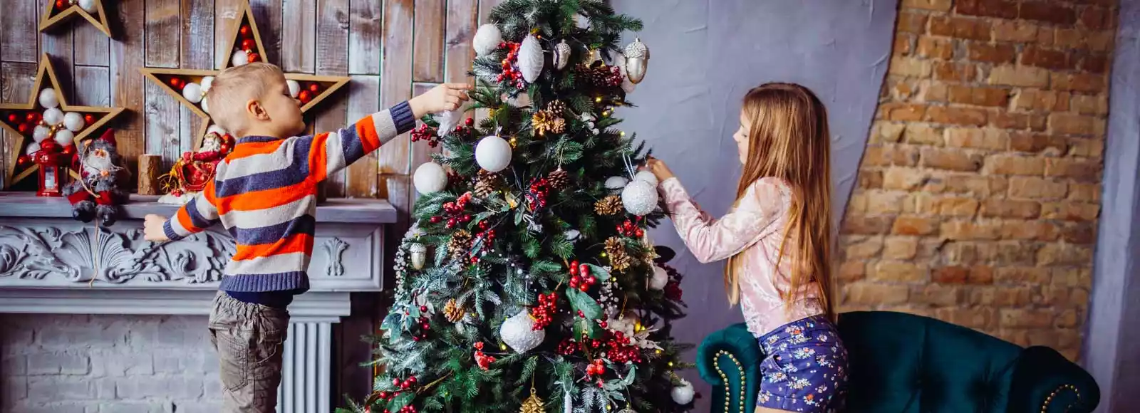 Zwei kleine Kinder schmücken einen Weihnachtsbaum
