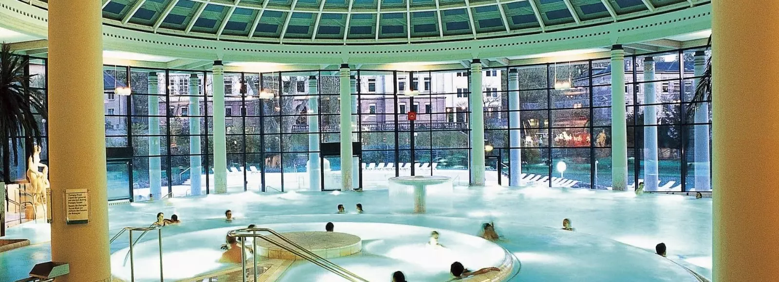 Blick über den Innenpool mit großer Fensterfront in der Caracalla Therme