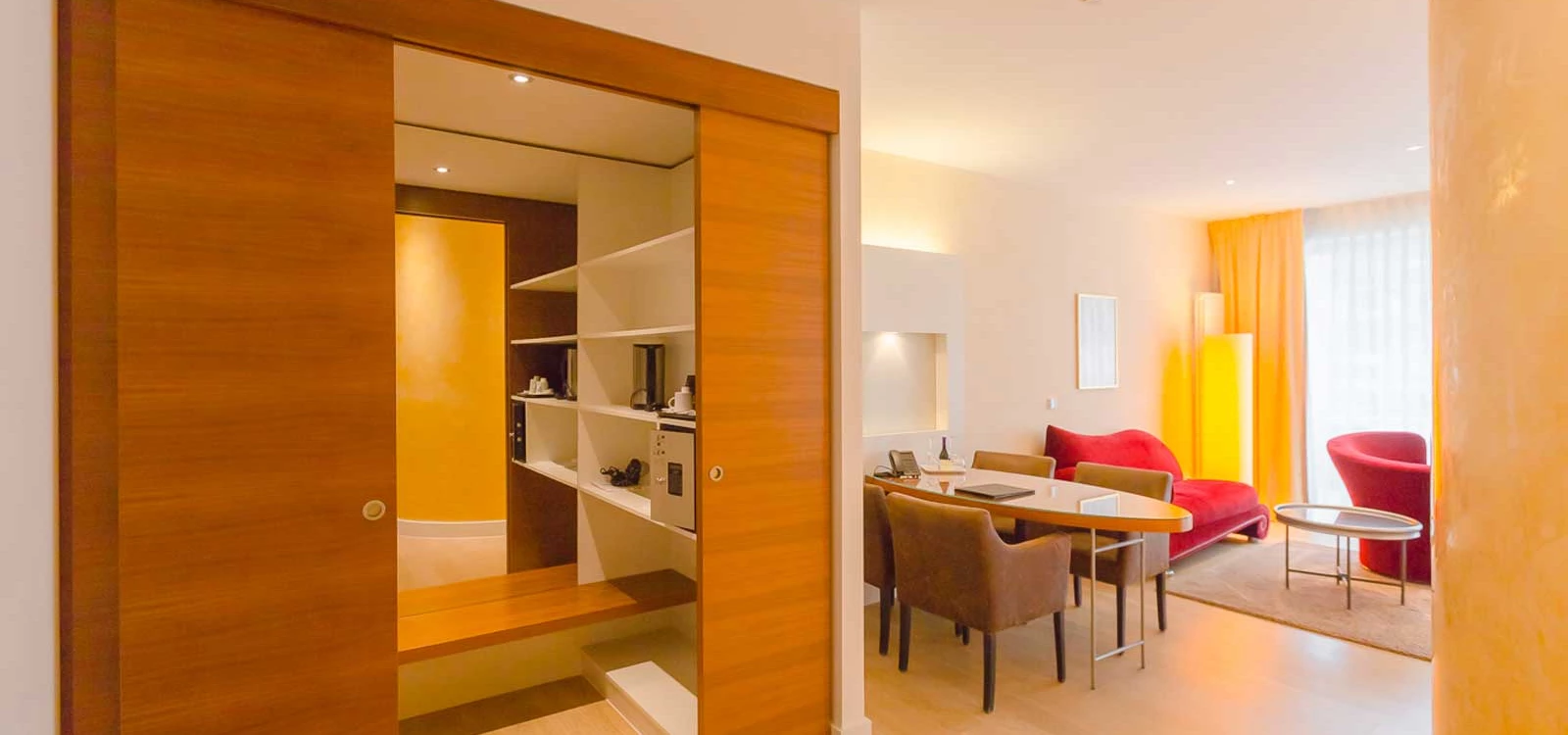 Arrangement aus einer Suite im Hotel in Baden-Baden und einem auf der Wiese picknickenden Pärchens